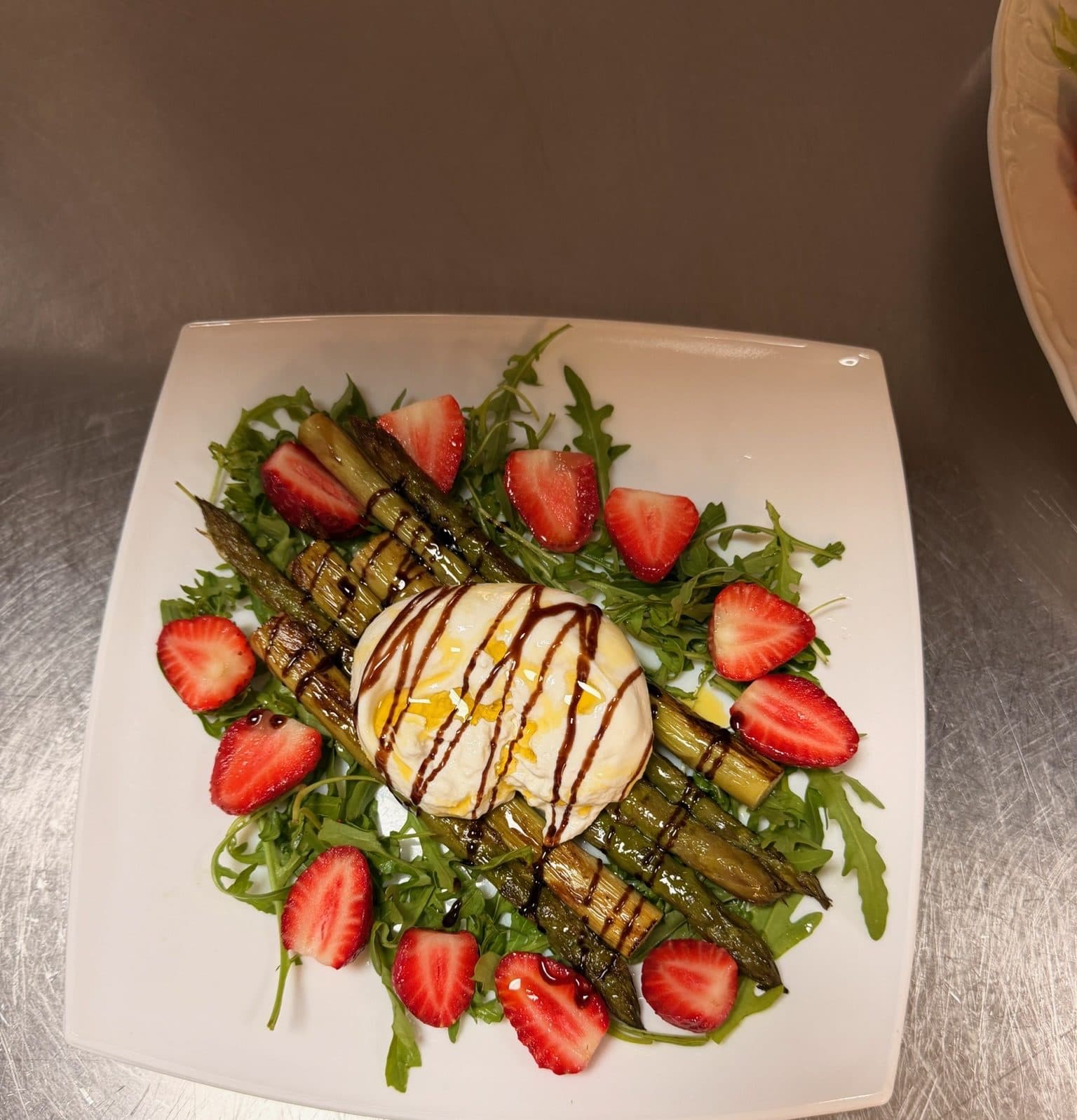 Burrata on rocket and grilled vegetables with strawberries and balsamic