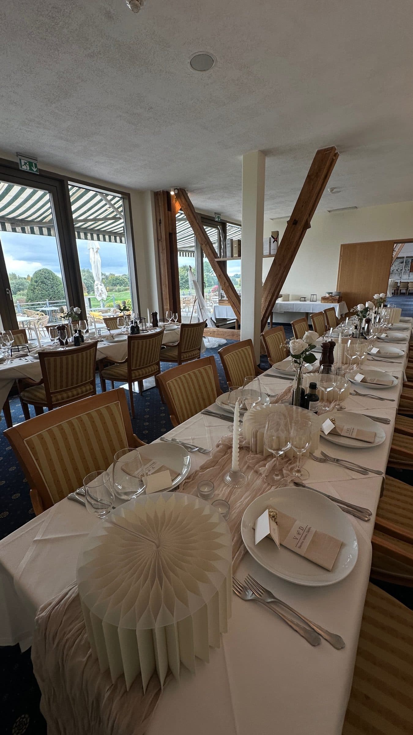 A long table by the window, festively laid with paper fans, candles and place cards