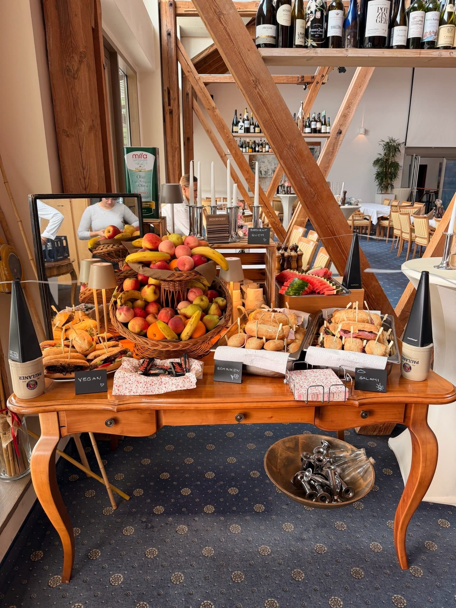Dessert- und Obstbuffet auf einem Holztisch unter dem Dachstuhl